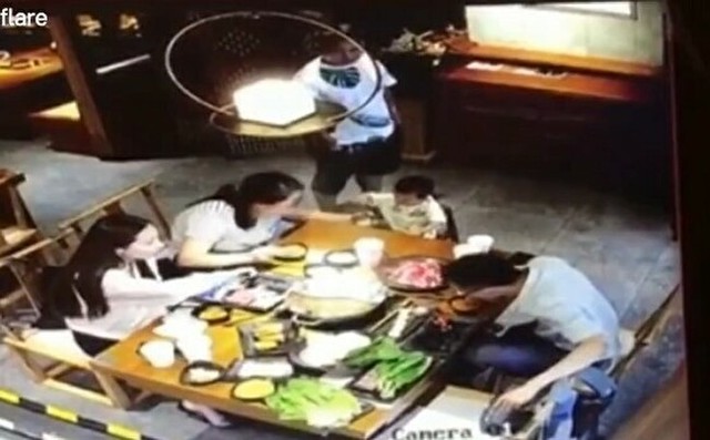中国の中華レストランで熱々の鍋をかけられる男.jpg