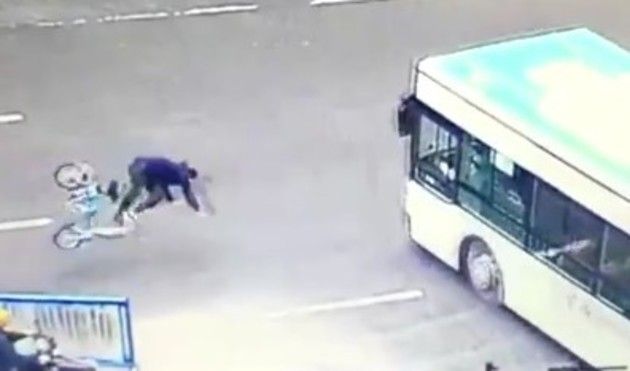 バスの前輪に頭から突っ込む人