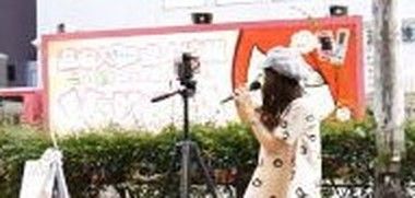 バニラの宣伝カーに邪魔されるストリートミュージシャン